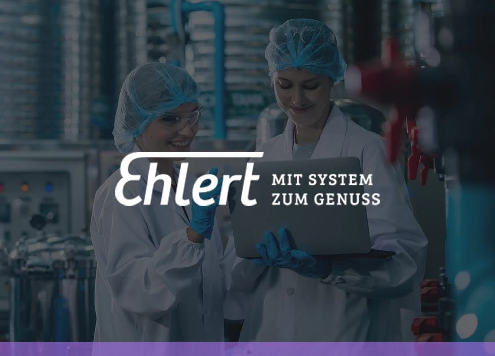 Zwei Mitarbeiterinnen in Laborkleidung betrachten gemeinsam einen Laptop, mit dem Ehlert-Logo im Hintergrund.
